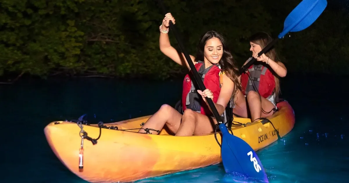 Two paddlers in a tandem kayak on a bioluminescent bay kayak tour in Puerto Rico at night