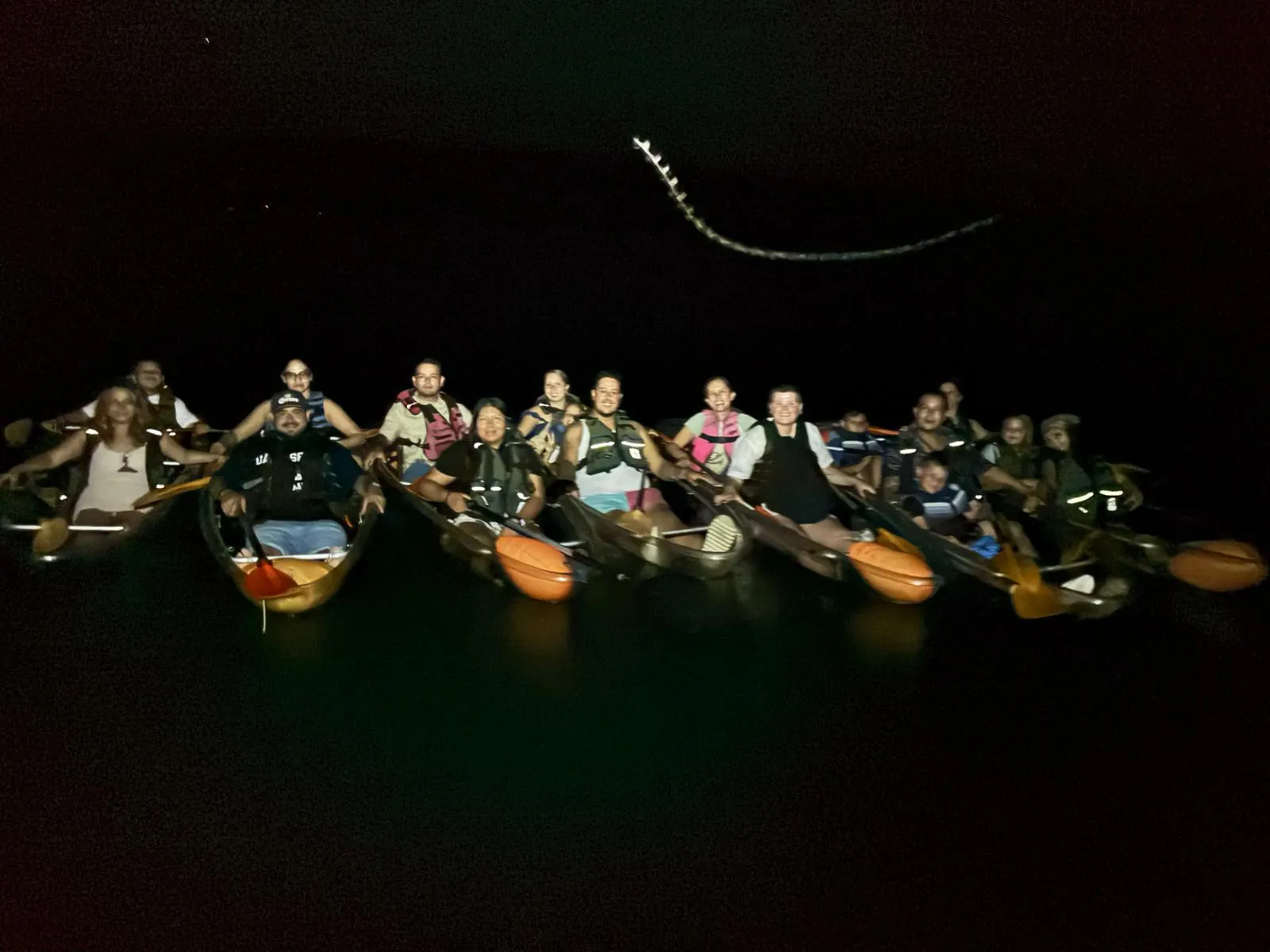 A group of kayakers gathered on Mosquito Bay in Vieques under a dark sky
